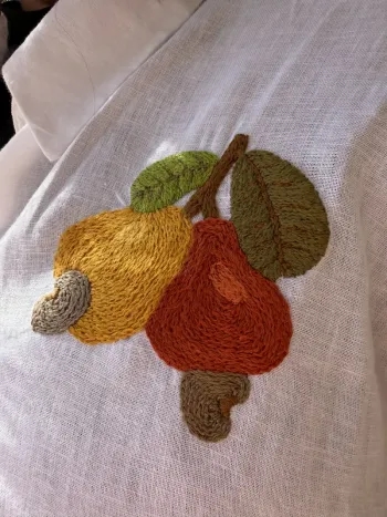 Bordado de frutas em linho branco feito por Evelyne Almeida