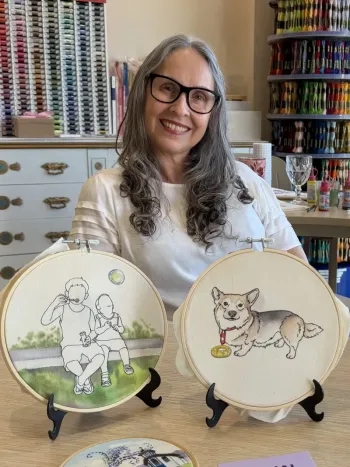 Giselle Vargas com os bordados de crianças e de um cachorro