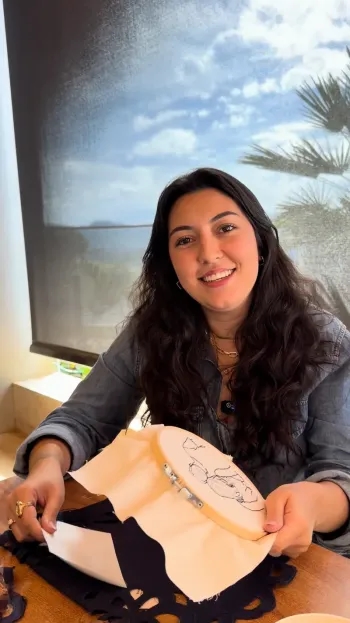 Larissa Sadok segurando o bastidor com o risco do casal