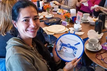 Vanessa Morgado segurando o bordado de Diamantina que ela fez