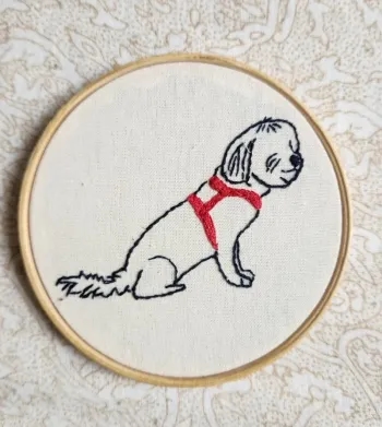 Bordado de um cachorrinho com peitoral vermelho