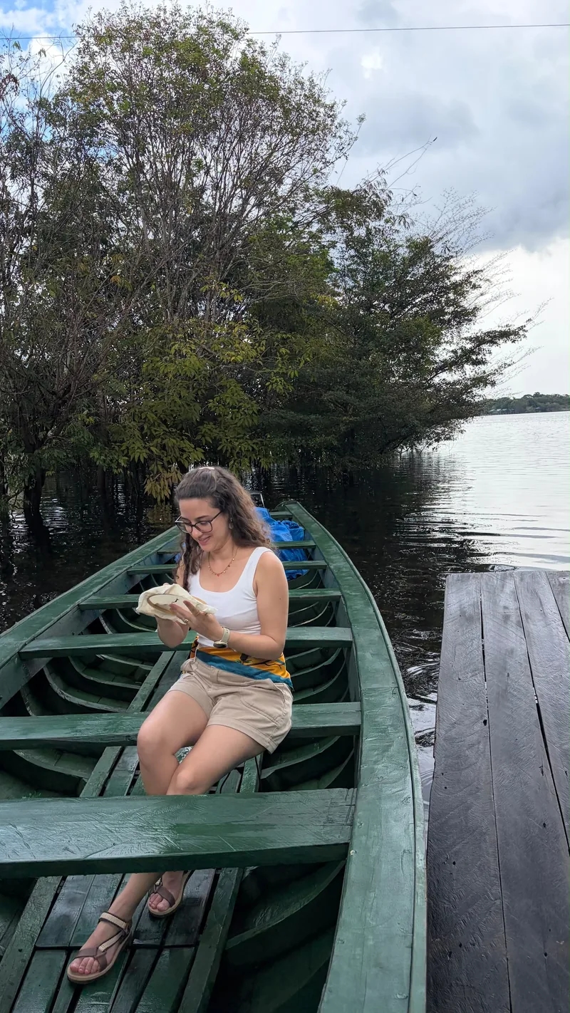 Foto original de uma mulher sentada em uma canoa no rio